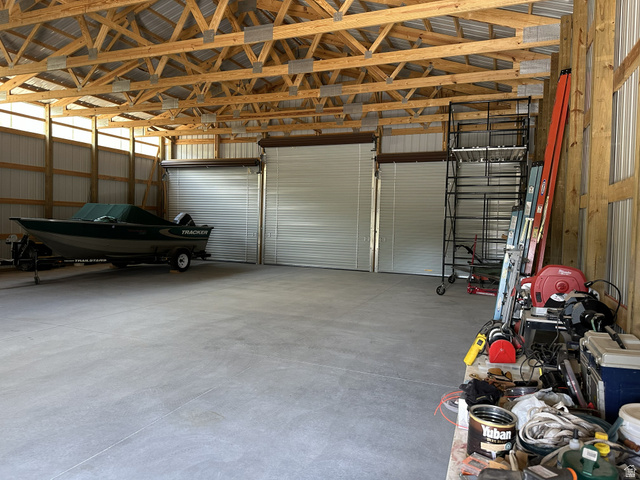 2006 Swenson Valley Road Bancroft, ID 83217 - Photo 26 of 51 Spacious outbuilding featuring a concrete floor, exposed wood truss ceiling, and three roll-up doors for versatile access