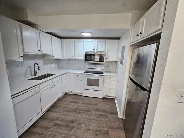 a kitchen with white cabinets stainless steel appliances and a sink