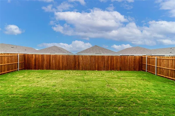 a view of a backyard with wooden fence