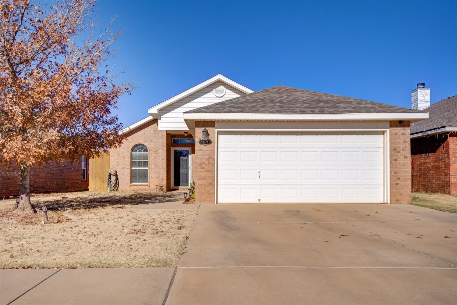 6514 86th Street Lubbock, TX 79424 - Photo 1 of 34 a front view of a house with a yard and garage