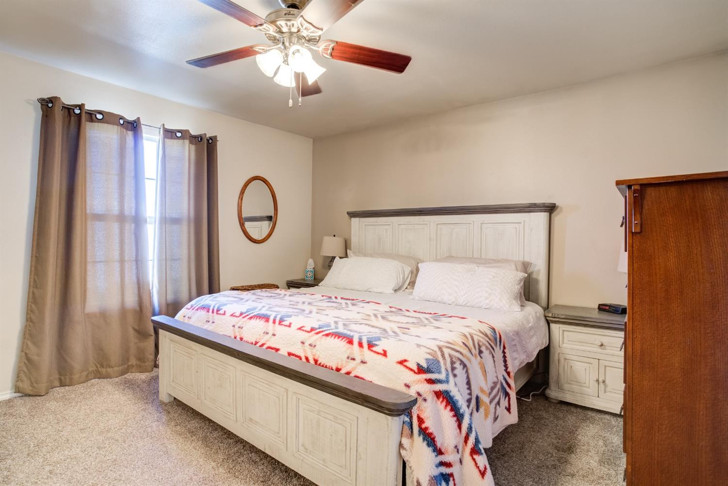 6514 86th Street Lubbock, TX 79424 - Photo 20 of 34 a bedroom with a bed and a chandelier