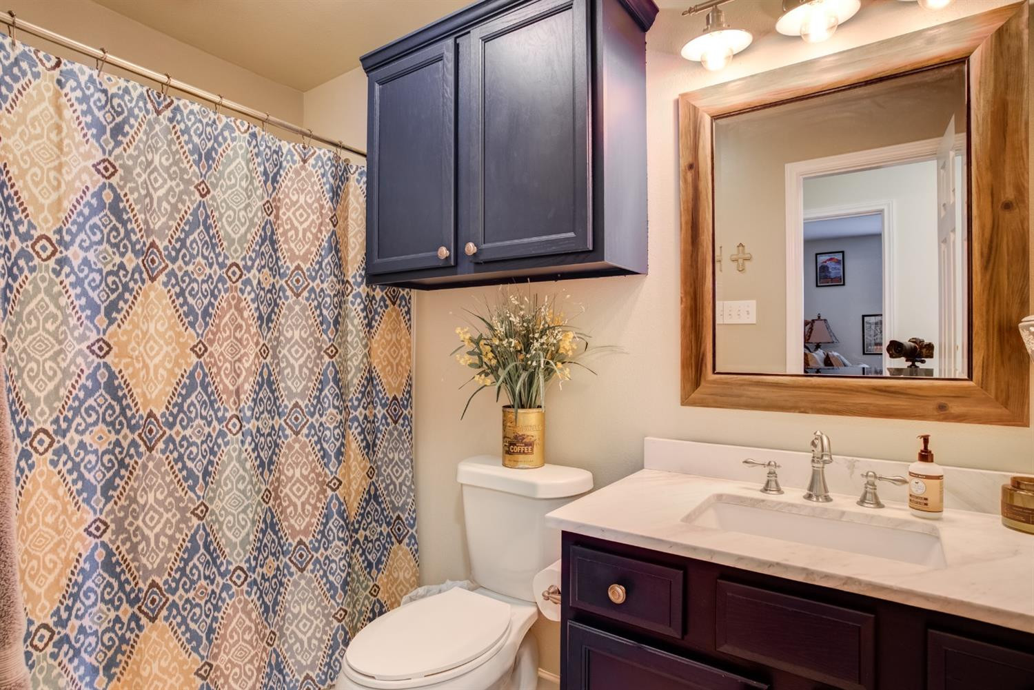 6514 86th Street Lubbock, TX 79424 - Photo 30 of 34 a bathroom with a granite countertop sink toilet and mirror