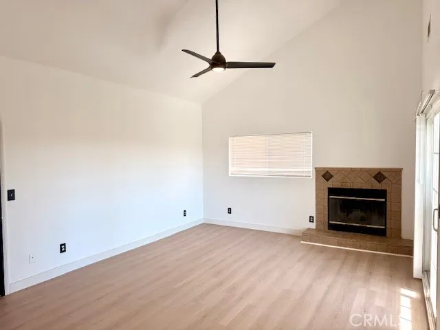 a view of empty room with wooden floor and fireplace