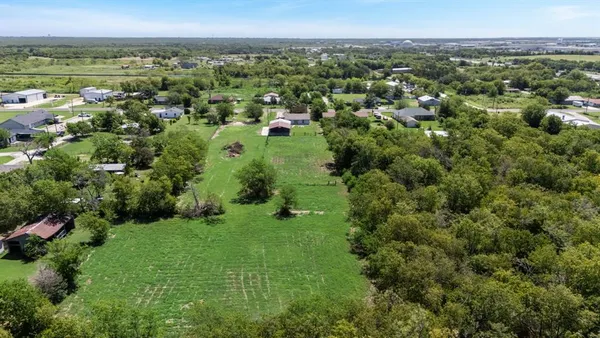 an aerial view of green landscape with trees houses and mountain view
