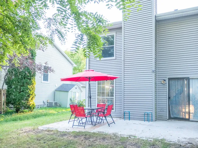 a patio with a table and chairs under an umbrella