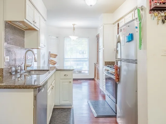 a kitchen with stainless steel appliances granite countertop a refrigerator and a sink