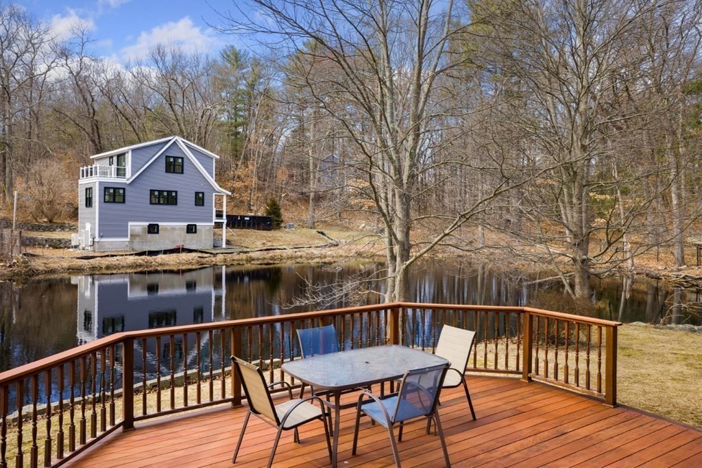 1 Mill Street Middleton, MA 01949 - Photo 12 of 30 a view of a roof deck with table and chairs with wooden floor and fence