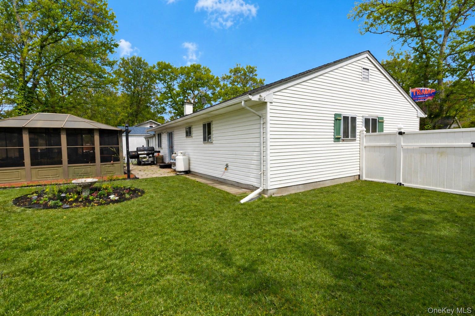 11 Seaford Road Mastic Beach, NY 11951 - Photo 14 of 19 a view of a white house with a yard and plants
