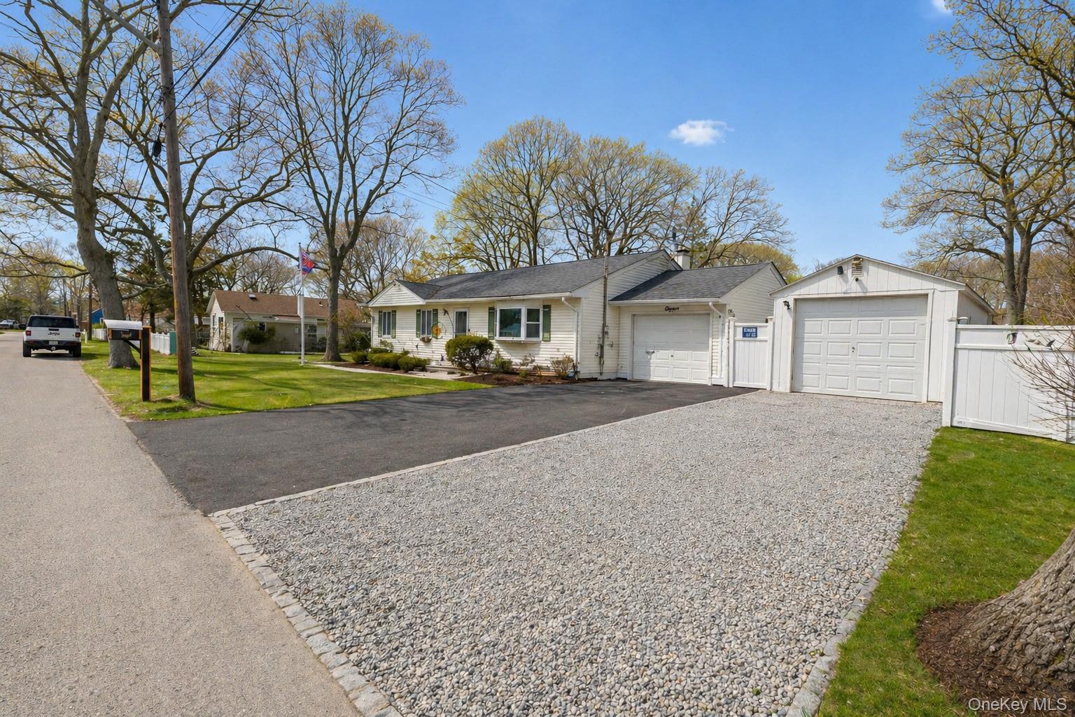 11 Seaford Road Mastic Beach, NY 11951 - Photo 2 of 19 a front view of a house with a yard and garage