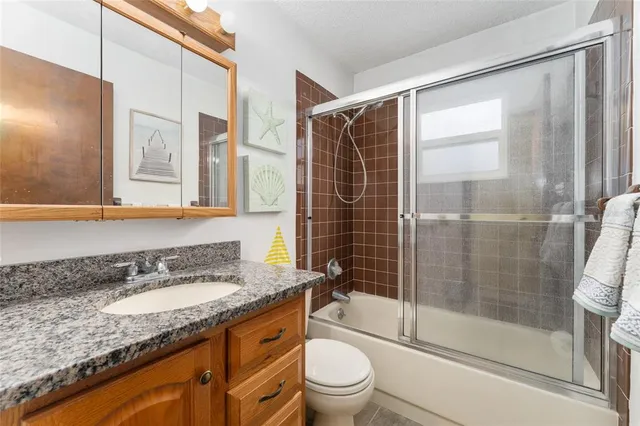 a bathroom with a granite countertop sink a mirror and a shower