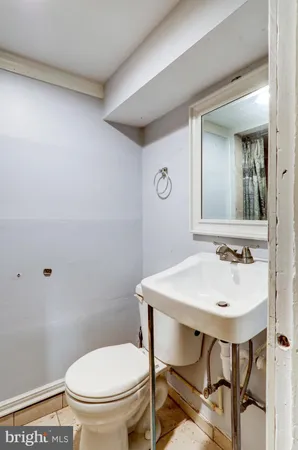 a bathroom with a toilet a sink and mirror