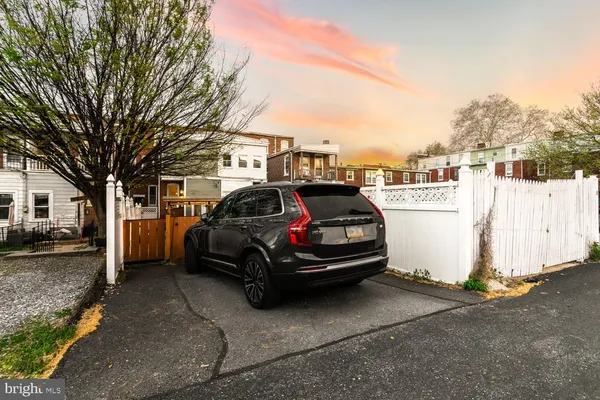 a car parked in front of a white house