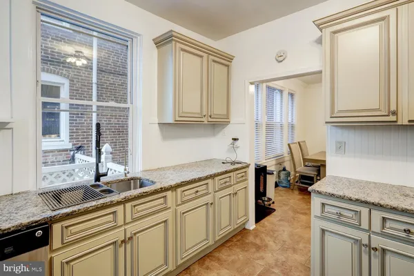 a kitchen with granite countertop a sink and a stove