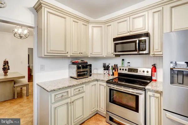 a kitchen with granite countertop cabinets stainless steel appliances and a sink