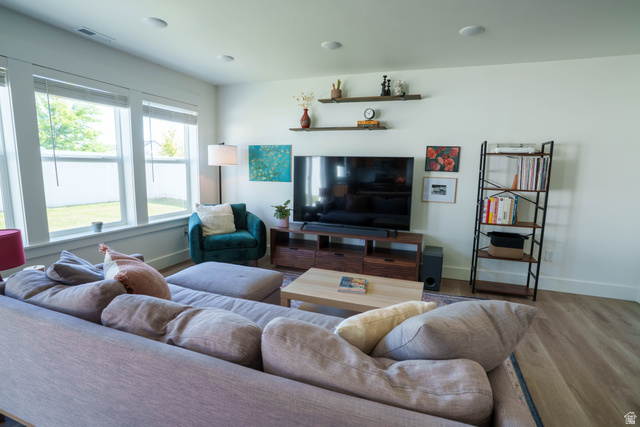 1486 West 2055th Street South Logan, UT 84339 - Photo 13 of 45 Living area featuring expansive windows with white trim, wood-finish flooring, and recessed ceiling lighting
