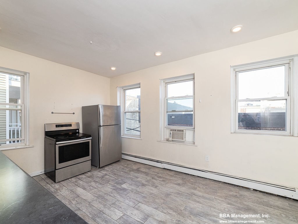 25 Chester Street, Unit 4 Boston, MA 02134 - Photo 3 of 12 a kitchen with stainless steel appliances granite countertop a stove a refrigerator and a microwave
