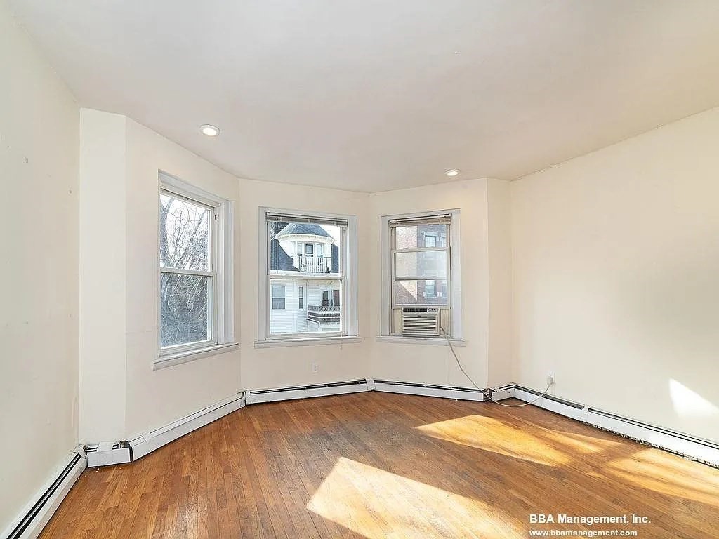 25 Chester Street, Unit 4 Boston, MA 02134 - Photo 5 of 12 an empty room with wooden floor and windows