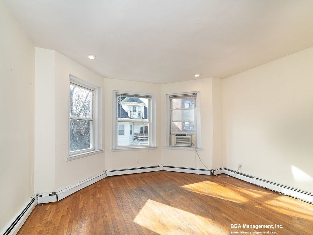 25 Chester Street, Unit 4 Boston, MA 02134 - Photo 6 of 12 an empty room with wooden floor and windows