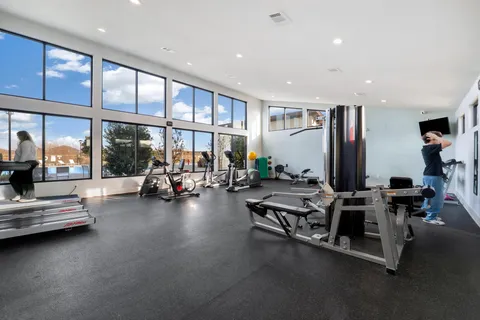 a view of a room with gym equipment and floor to ceiling window