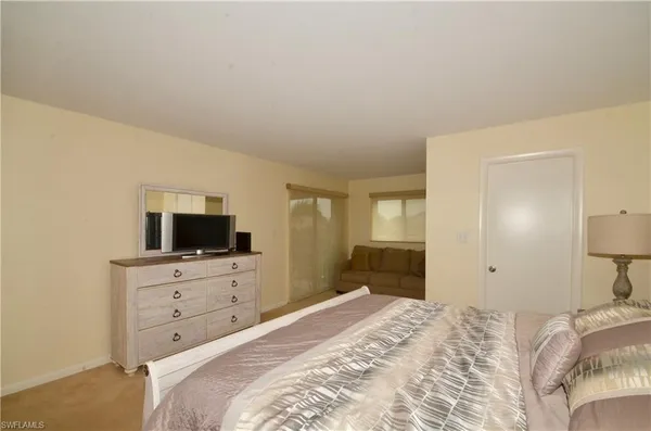 a bedroom with a bed and a flat tv screen on wall