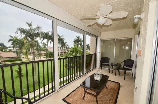 a view of a balcony with furniture and floor to ceiling window