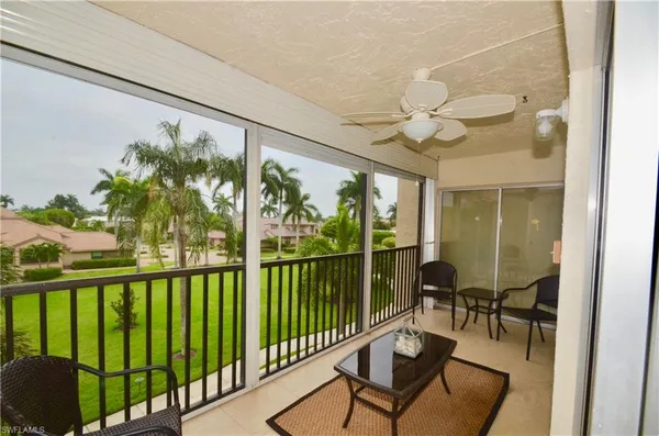 a living room with large windows and furniture