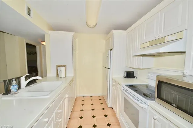 a kitchen with a sink stove and refrigerator