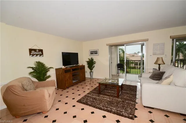 a living room with furniture a flat screen tv and a rug