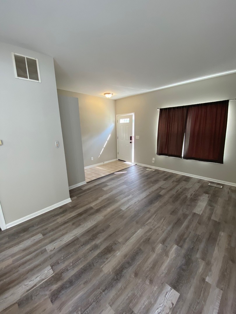 318 Richfield Trail Romeoville, IL 60446 - Photo 3 of 9 a view of an empty room with wooden floor and a cabinet