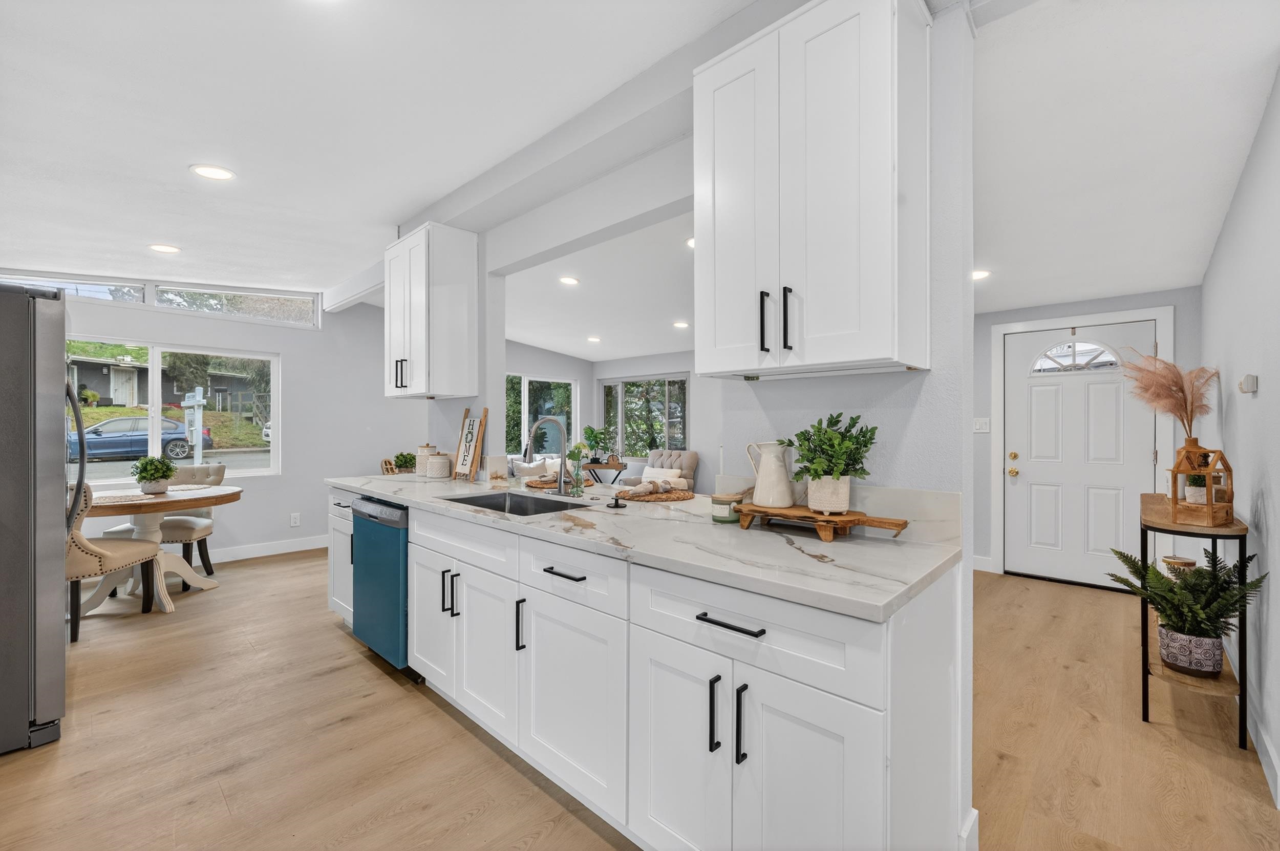 1241 Coronel Avenue Vallejo, CA 94591 - Photo 3 of 11 Kitchen featuring light stone counters, white cabinets, light wood-type flooring, freestanding refrigerator, and recessed lighting