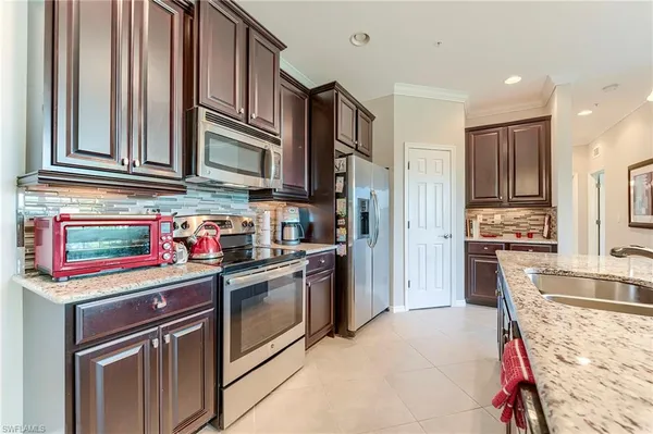 a kitchen with stainless steel appliances granite countertop a refrigerator and a stove top oven