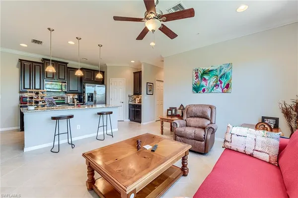 a living room with furniture kitchen view and a chandelier