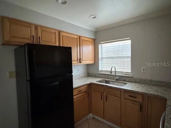 a kitchen with a sink a refrigerator and cabinets