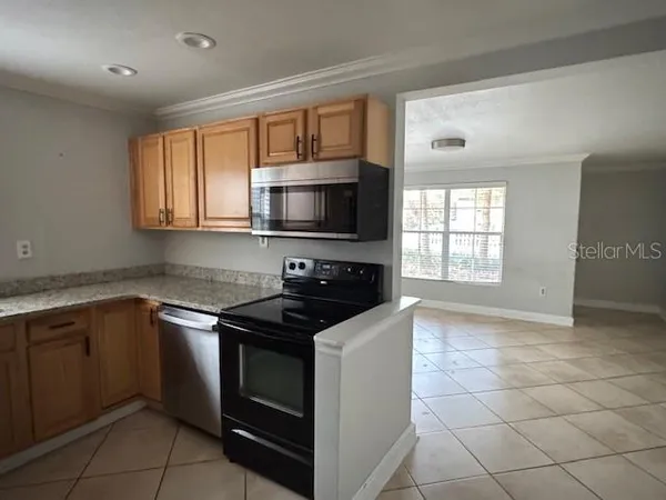 a kitchen with granite countertop a stove top oven microwave and cabinets