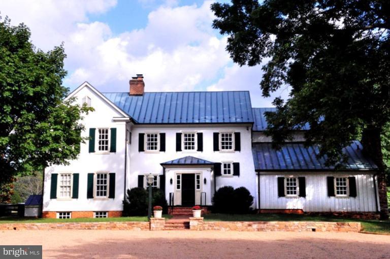 3032 Bull Run Mountain Road The Plains, VA 20198 - Photo 1 of 16 a view of a white house with a large windows and a large tree with wooden fence
