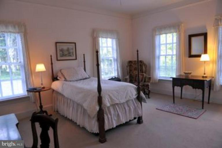 3032 Bull Run Mountain Road The Plains, VA 20198 - Photo 13 of 16 a bedroom with a bed table chair and windows