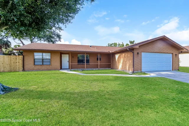 a view of a house with a backyard