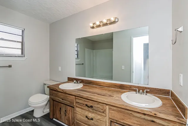 a bathroom with a granite countertop sink mirror and toilet