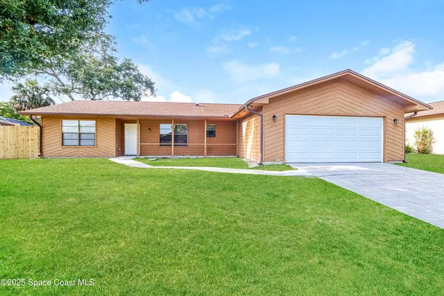 a front view of house with yard and green space