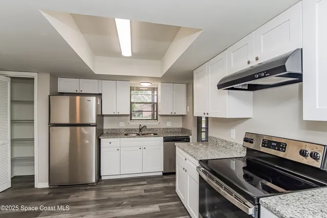 a kitchen with a stove a refrigerator and a sink