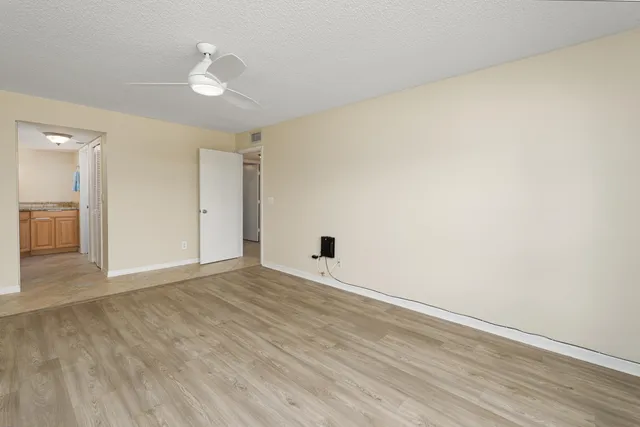 a view of an empty room with wooden floor