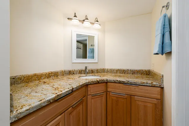 a bathroom with a granite countertop sink and a mirror