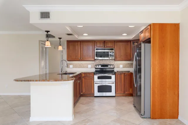 a kitchen with stainless steel appliances granite countertop a refrigerator and a stove