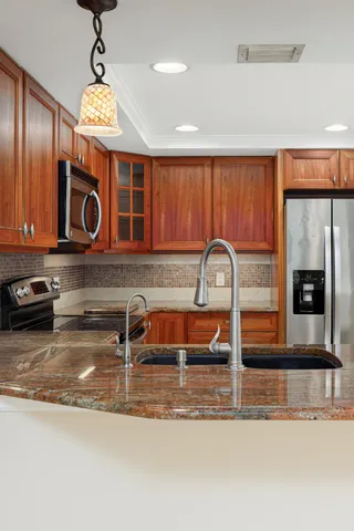 a kitchen with stainless steel appliances granite countertop a sink and a microwave