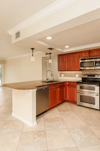 a kitchen with granite countertop a stove and cabinets