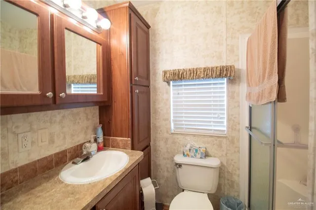 a bathroom with a sink toilet a mirror and tub