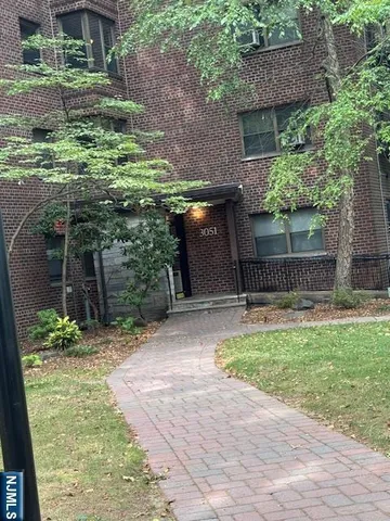 a backyard of a house with plants and brick wall