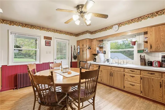 a view of a dining room with furniture a chandelier and kitchen view