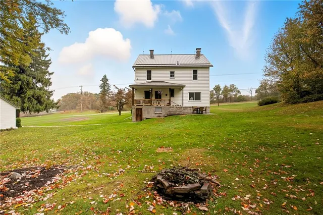 a view of a chair and table in backyard of the house