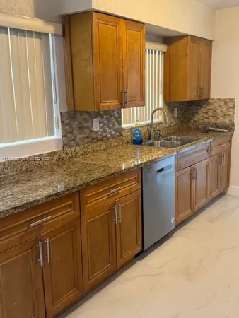 a kitchen with stainless steel appliances granite countertop a sink a stove and cabinets